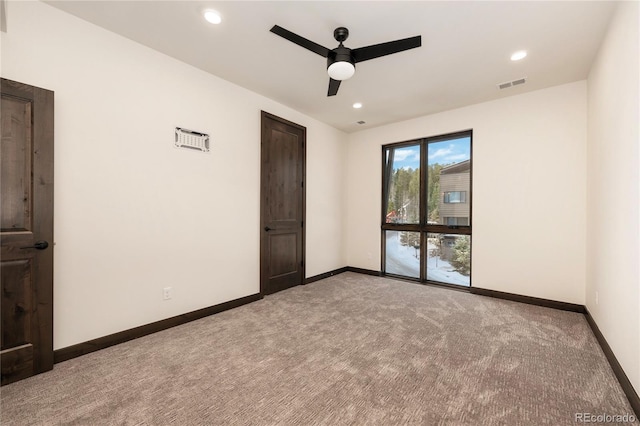 carpeted spare room featuring ceiling fan