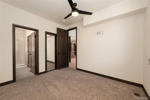 unfurnished bedroom with ceiling fan, ensuite bath, and light colored carpet