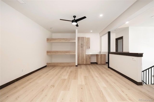 unfurnished living room featuring ceiling fan and light wood-type flooring