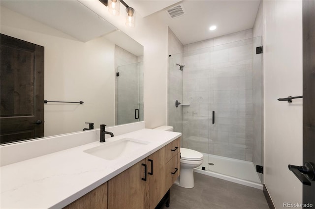 bathroom with vanity, an enclosed shower, and toilet