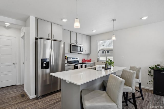 5121 N Yampa St, Denver, CO 80249 - kitchen with stainless steel appliances, a sink, dark wood-style floors, light countertops, and a kitchen bar