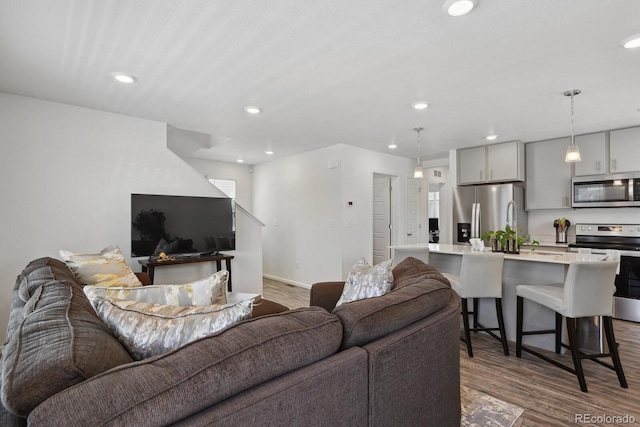 5121 N Yampa St, Denver, CO 80249 - living area featuring recessed lighting, wood finished floors, baseboards, and stairway
