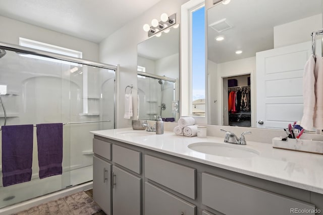 5121 N Yampa St, Denver, CO 80249 - bathroom with a stall shower, double vanity, a spacious closet, and recessed lighting