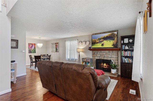 8452 Everett Way Unit C, Arvada, CO 80005 - living room featuring a textured ceiling, wood finished floors, a fireplace, and a chandelier