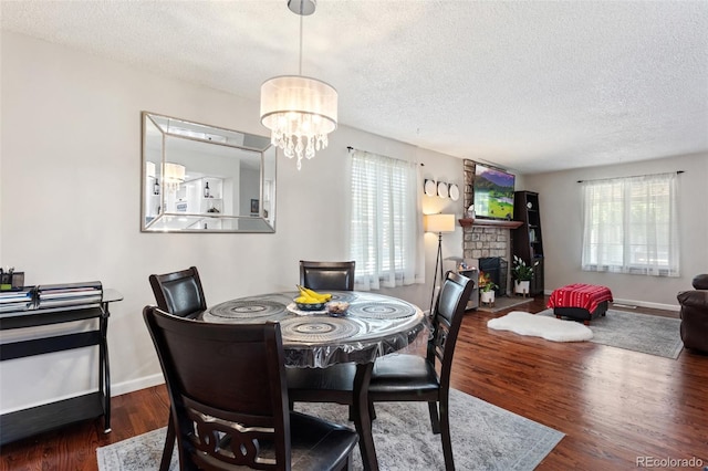 8452 Everett Way Unit C, Arvada, CO 80005 - dining area with a textured ceiling, wood finished floors, a chandelier, and a lit fireplace