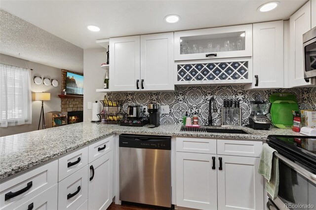 8452 Everett Way Unit C, Arvada, CO 80005 - kitchen featuring stainless steel appliances, white cabinetry, backsplash, and light stone countertops