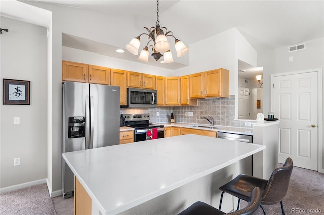 4501 Nelson Rd Unit 2201, Longmont, CO 80503 - kitchen featuring stainless steel appliances, a chandelier, light countertops, backsplash, and light colored carpet