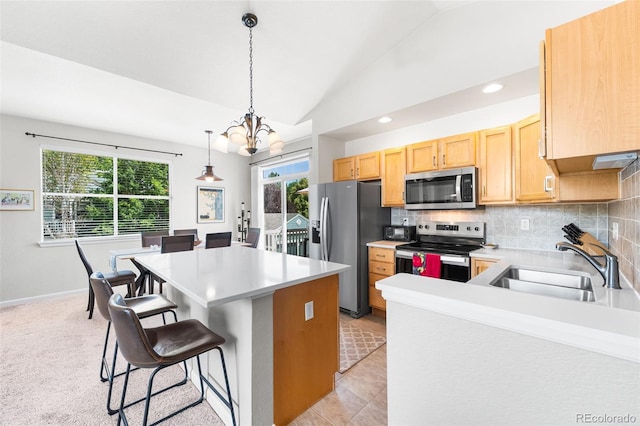 4501 Nelson Rd Unit 2201, Longmont, CO 80503 - kitchen with stainless steel appliances, a chandelier, lofted ceiling, light countertops, and backsplash