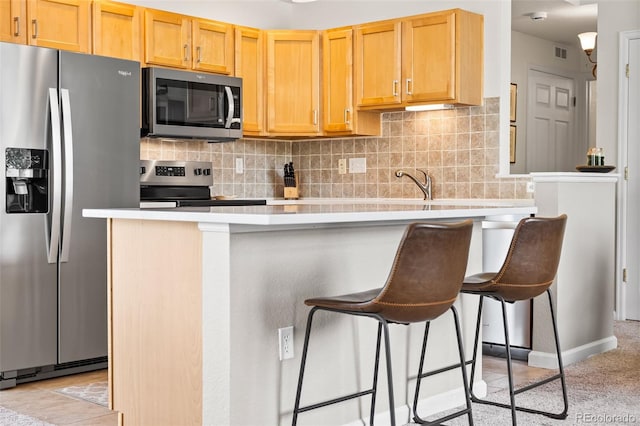 4501 Nelson Rd Unit 2201, Longmont, CO 80503 - kitchen with appliances with stainless steel finishes, light countertops, tasteful backsplash, and a kitchen breakfast bar