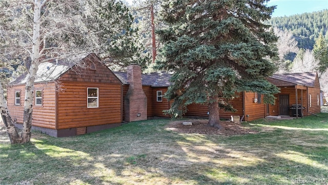 7 Rock Canyon Rd, Drake, CO 80515 - rear view of property featuring a yard, roof with shingles, a chimney, and faux log siding