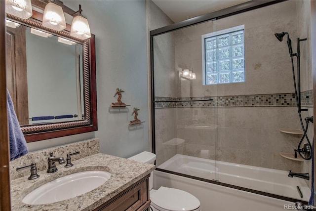 bathroom featuring toilet, vanity, and shower / bath combination with glass door