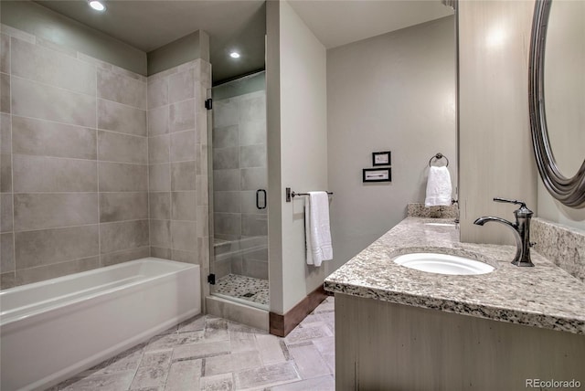 bathroom featuring a sink, a tub, recessed lighting, a shower stall, and double vanity