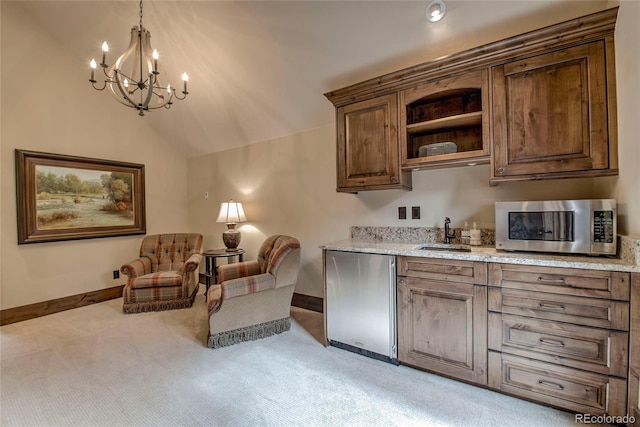 interior space with a sink, stainless steel microwave, fridge, light colored carpet, and vaulted ceiling