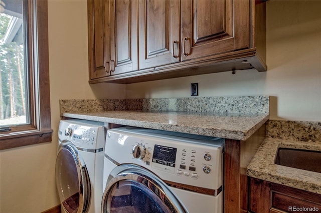 clothes washing area with cabinet space and washing machine and dryer