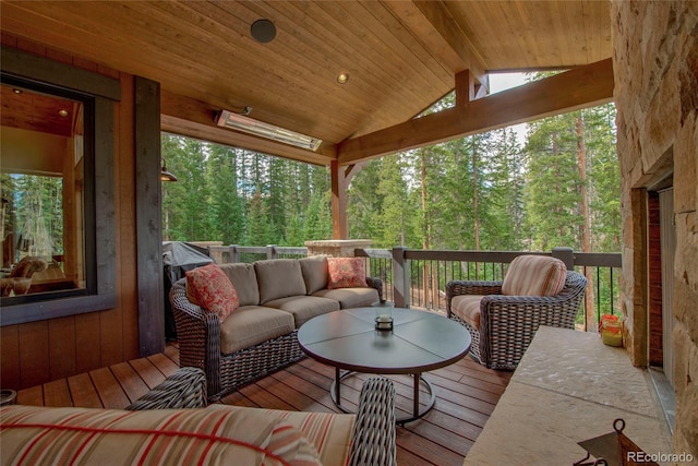 sunroom / solarium featuring lofted ceiling with beams, a forest view, and wood ceiling