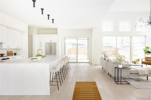 3530 Fenton St, Wheat Ridge, CO 80212 - kitchen with high end fridge, a sink, open floor plan, and a kitchen breakfast bar