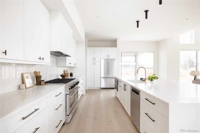 3530 Fenton St, Wheat Ridge, CO 80212 - kitchen with premium appliances, a sink, light wood-style floors, tasteful backsplash, and a large island