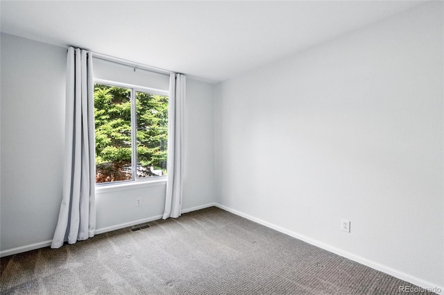 unfurnished room with carpet floors and baseboards