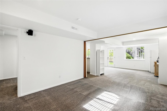 empty room featuring carpet flooring and baseboards