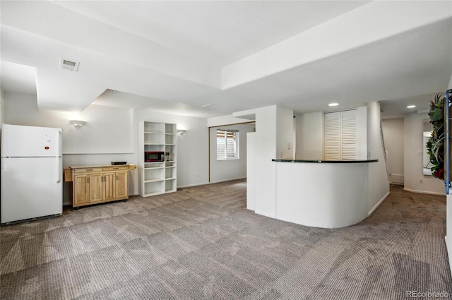 kitchen with freestanding refrigerator, light colored carpet, built in microwave, baseboards, and recessed lighting