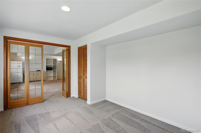 carpeted spare room featuring baseboards, french doors, and recessed lighting