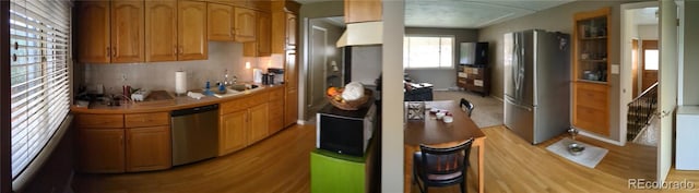 kitchen featuring appliances with stainless steel finishes, sink, and light hardwood / wood-style flooring