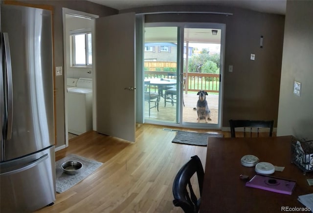 doorway with separate washer and dryer and light hardwood / wood-style flooring