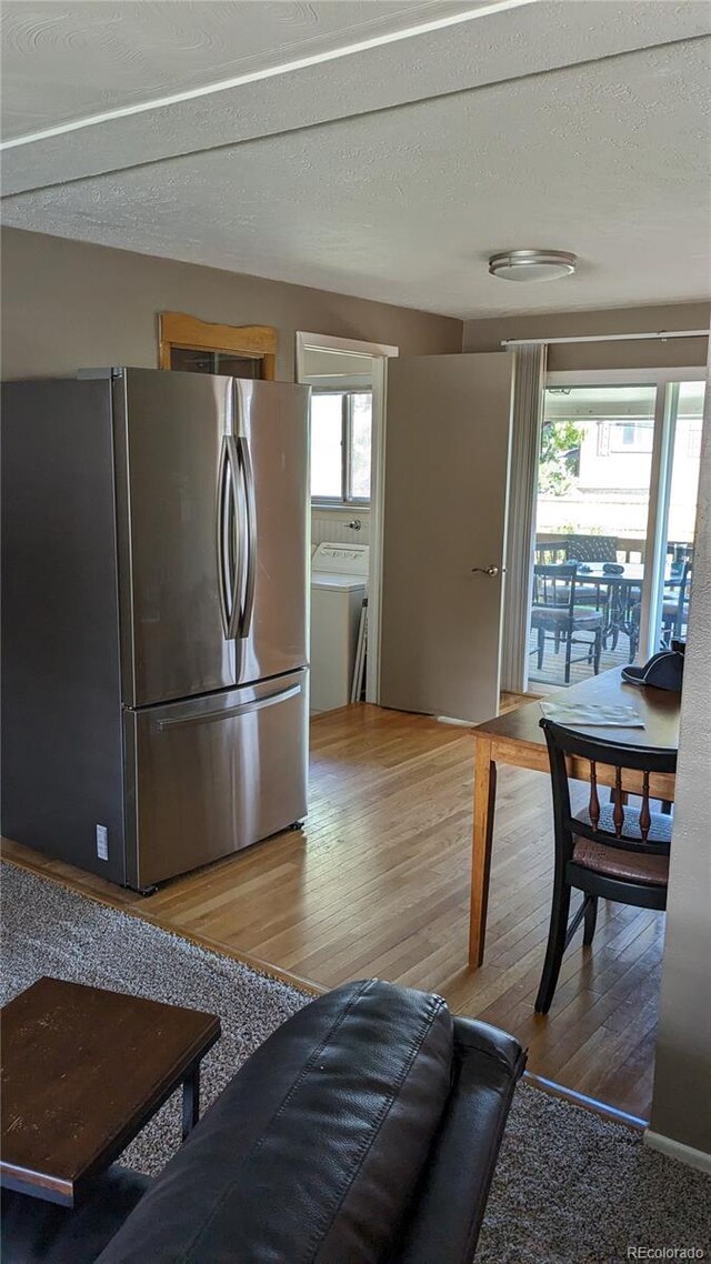 living room with washer / clothes dryer, wood-type flooring, and a textured ceiling