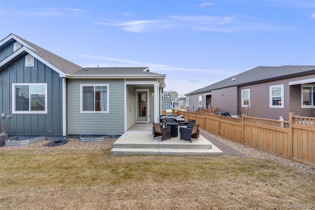 back of house with a patio and a lawn