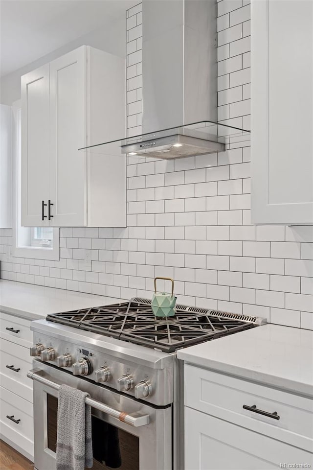 3478 Chase St, Wheat Ridge, CO 80212 - kitchen with high end range, wall chimney exhaust hood, light countertops, and white cabinetry