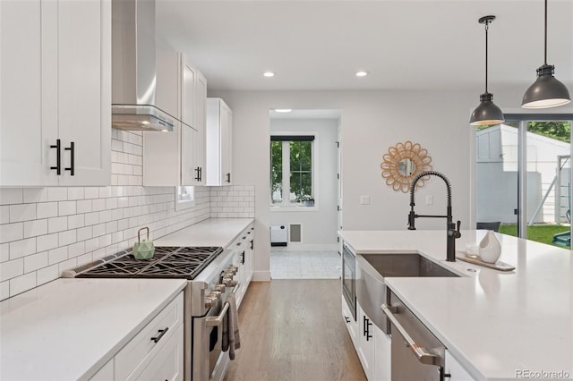 3478 Chase St, Wheat Ridge, CO 80212 - kitchen featuring appliances with stainless steel finishes, wall chimney range hood, tasteful backsplash, plenty of natural light, and recessed lighting
