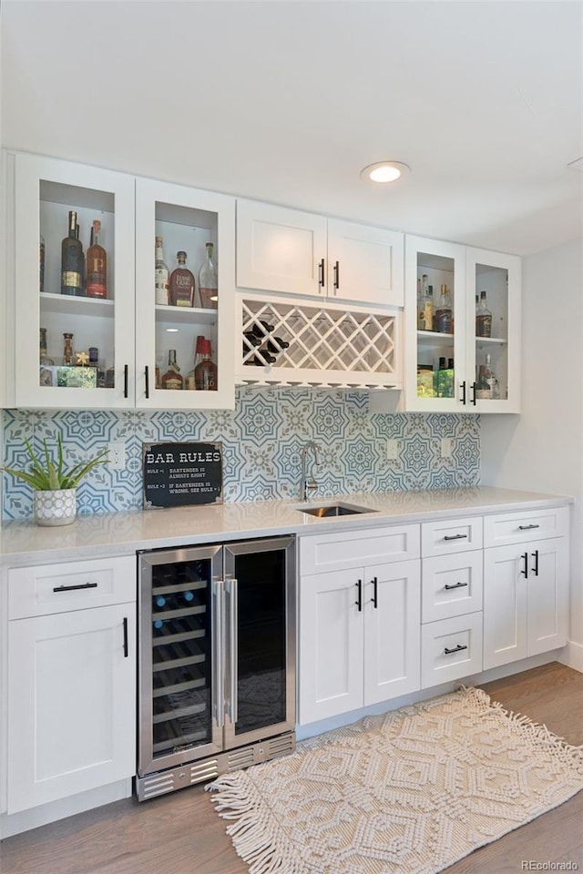 3478 Chase St, Wheat Ridge, CO 80212 - indoor bar featuring beverage cooler, tasteful backsplash, light wood-type flooring, and recessed lighting