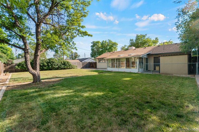 7310 Granada Rd, Denver, CO 80221 - fenced backyard featuring a sunroom and a gate