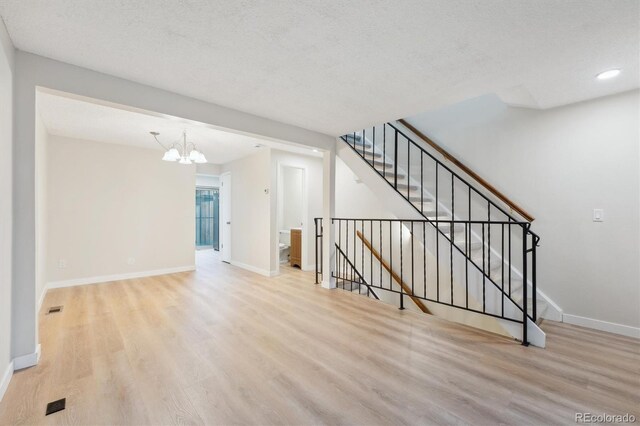 12927 W 20th Ave, Golden, CO 80401 - unfurnished living room featuring wood finished floors, baseboards, a chandelier, recessed lighting, and a textured ceiling