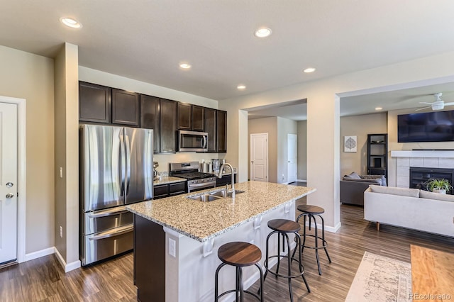 12851 Billingsley Trl, Parker, CO 80134 - kitchen with appliances with stainless steel finishes, open floor plan, dark wood-style floors, dark brown cabinets, and recessed lighting