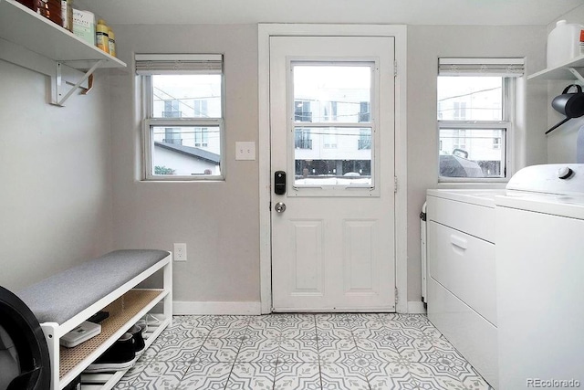 laundry area with laundry area, plenty of natural light, washing machine and dryer, and baseboards