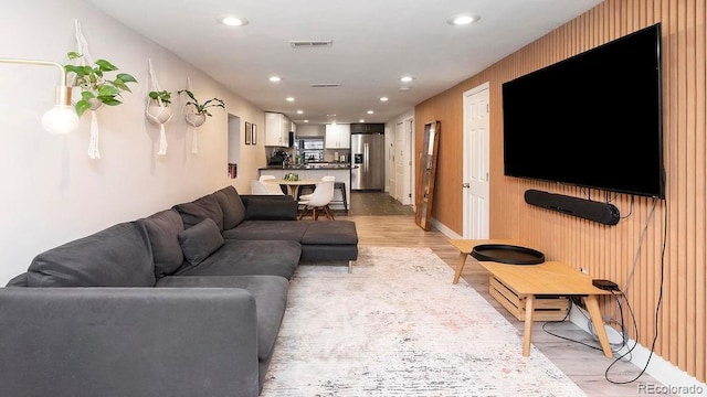 living room with recessed lighting, visible vents, and light wood finished floors