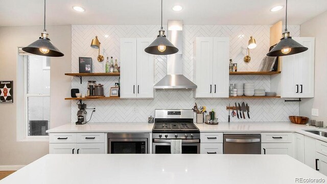 kitchen with open shelves, wall chimney exhaust hood, light countertops, and stainless steel appliances