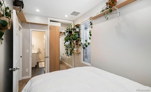 bedroom featuring ensuite bath, recessed lighting, visible vents, and baseboards