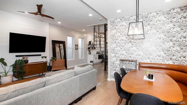 living room with light wood finished floors, recessed lighting, baseboards, and a ceiling fan