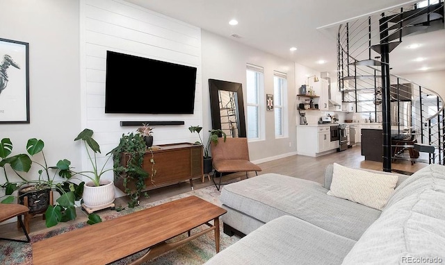 living room with recessed lighting, baseboards, stairs, and light wood finished floors