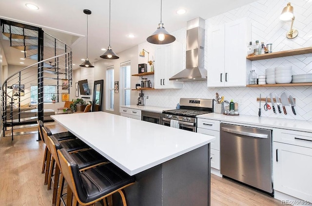 kitchen featuring open shelves, stainless steel appliances, white cabinetry, wall chimney exhaust hood, and tasteful backsplash