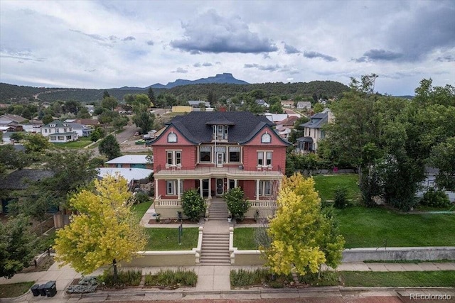 310 E 2nd St, Trinidad, CO 81082 - victorian home featuring stairway, a porch, a mountain view, and a front lawn