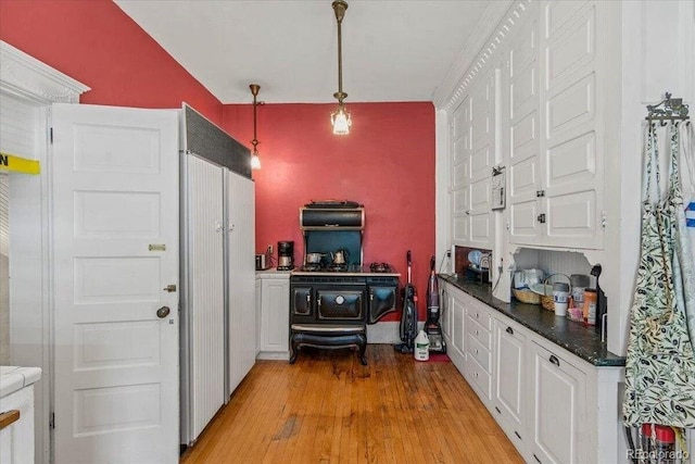 310 E 2nd St, Trinidad, CO 81082 - kitchen featuring white cabinets, dark countertops, pendant lighting, and light wood-style floors