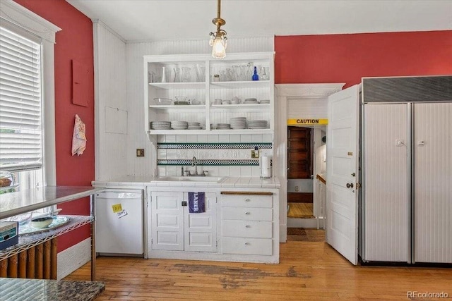 310 E 2nd St, Trinidad, CO 81082 - bar area featuring dishwashing machine, paneled refrigerator, light wood-style floors, and a sink