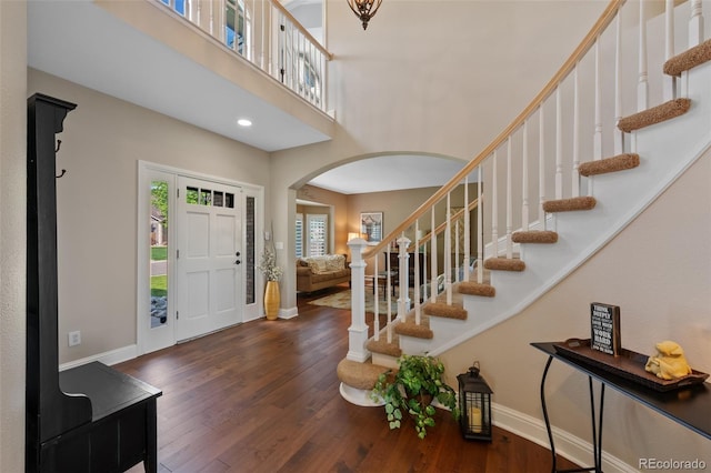 7056 S Owens St, Littleton, CO 80127 - entrance foyer featuring arched walkways, baseboards, wood finished floors, stairway, and a high ceiling