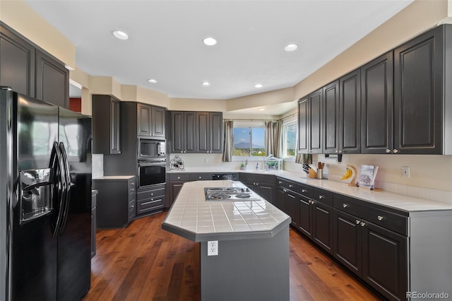 7056 S Owens St, Littleton, CO 80127 - kitchen with black appliances, a center island, tile counters, recessed lighting, and dark wood-type flooring