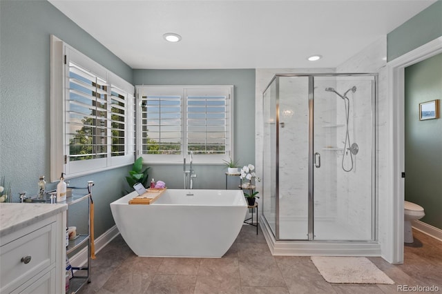 7056 S Owens St, Littleton, CO 80127 - full bathroom featuring a freestanding tub, a stall shower, toilet, baseboards, and vanity