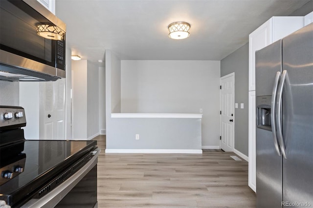 kitchen with white cabinetry, appliances with stainless steel finishes, and light hardwood / wood-style floors