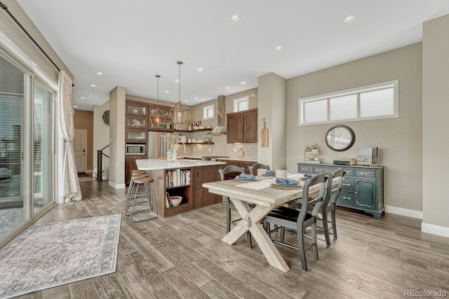 dining room with light wood-type flooring, baseboards, and recessed lighting